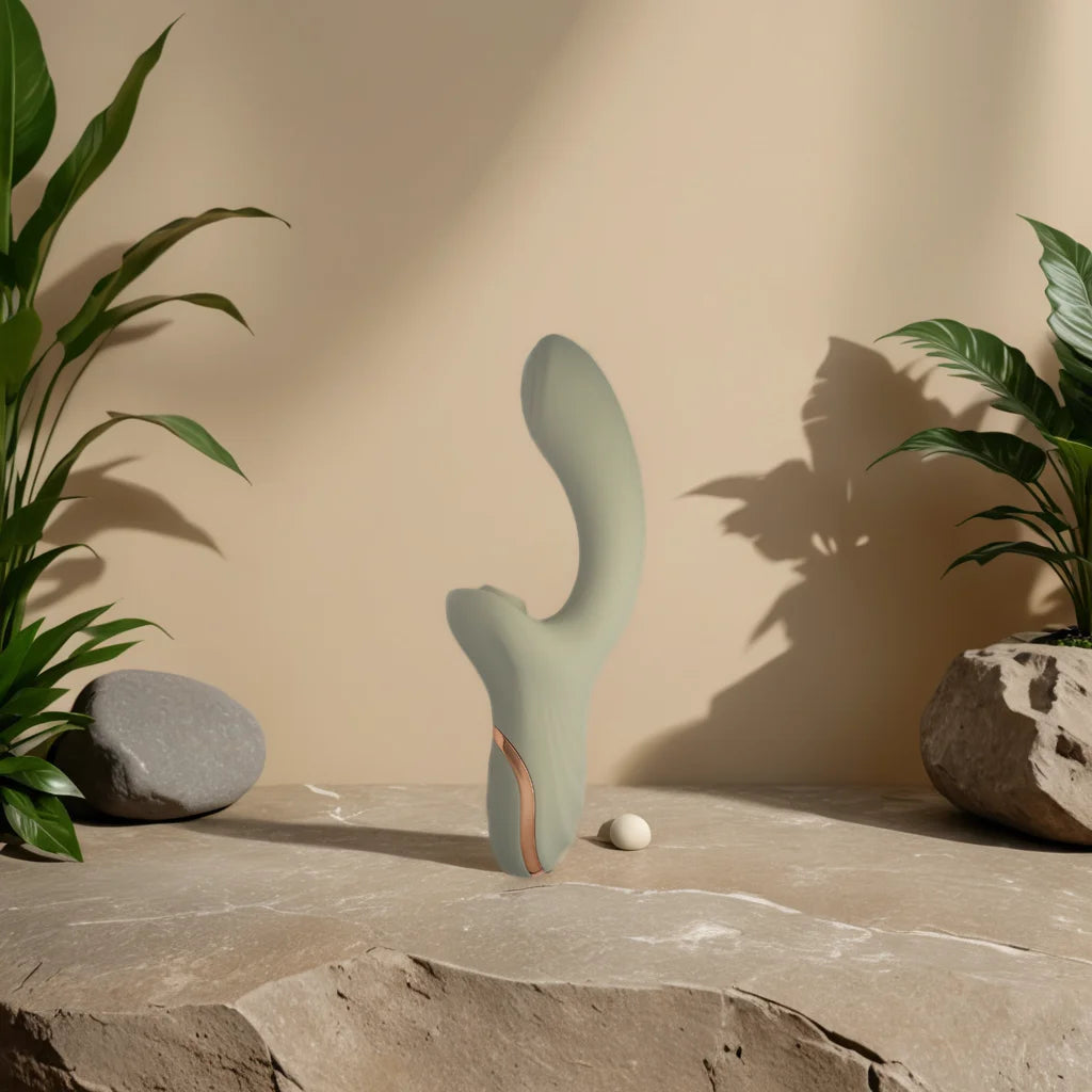 Vibromasseur rabbit Mila au design ergonomique posé sur une pierre, entouré de plantes, pour une double stimulation naturelle et élégante