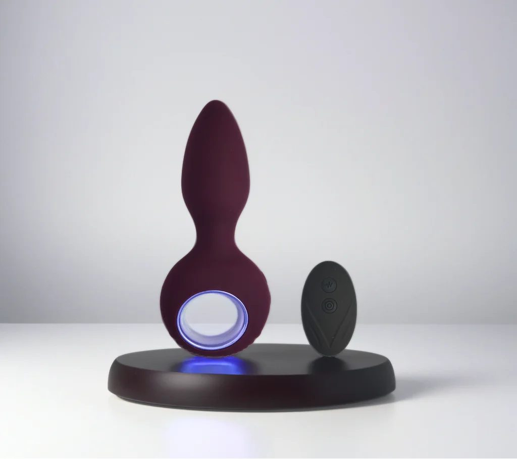 Plug anal vibrant télécommandé Rocco sur socle avec lumière bleue, design élégant et arrondi pour une exploration tout en douceur