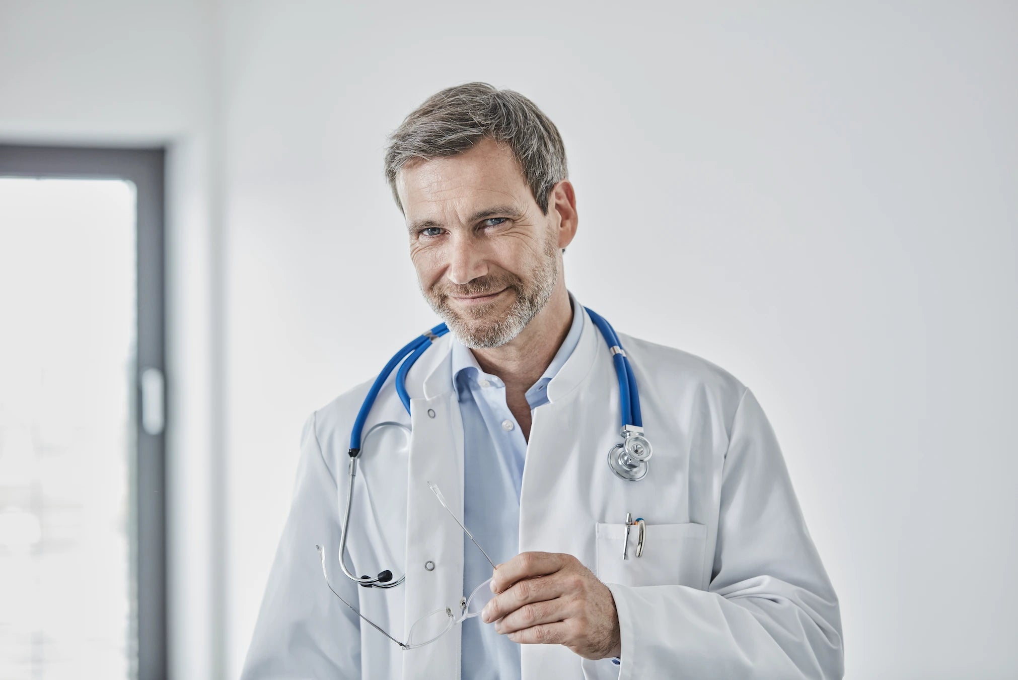 Médecin souriant en blouse blanche, illustrant l’approche bienveillante et sécurisée du massage de la prostate avec le sextoy Zoro de Solena