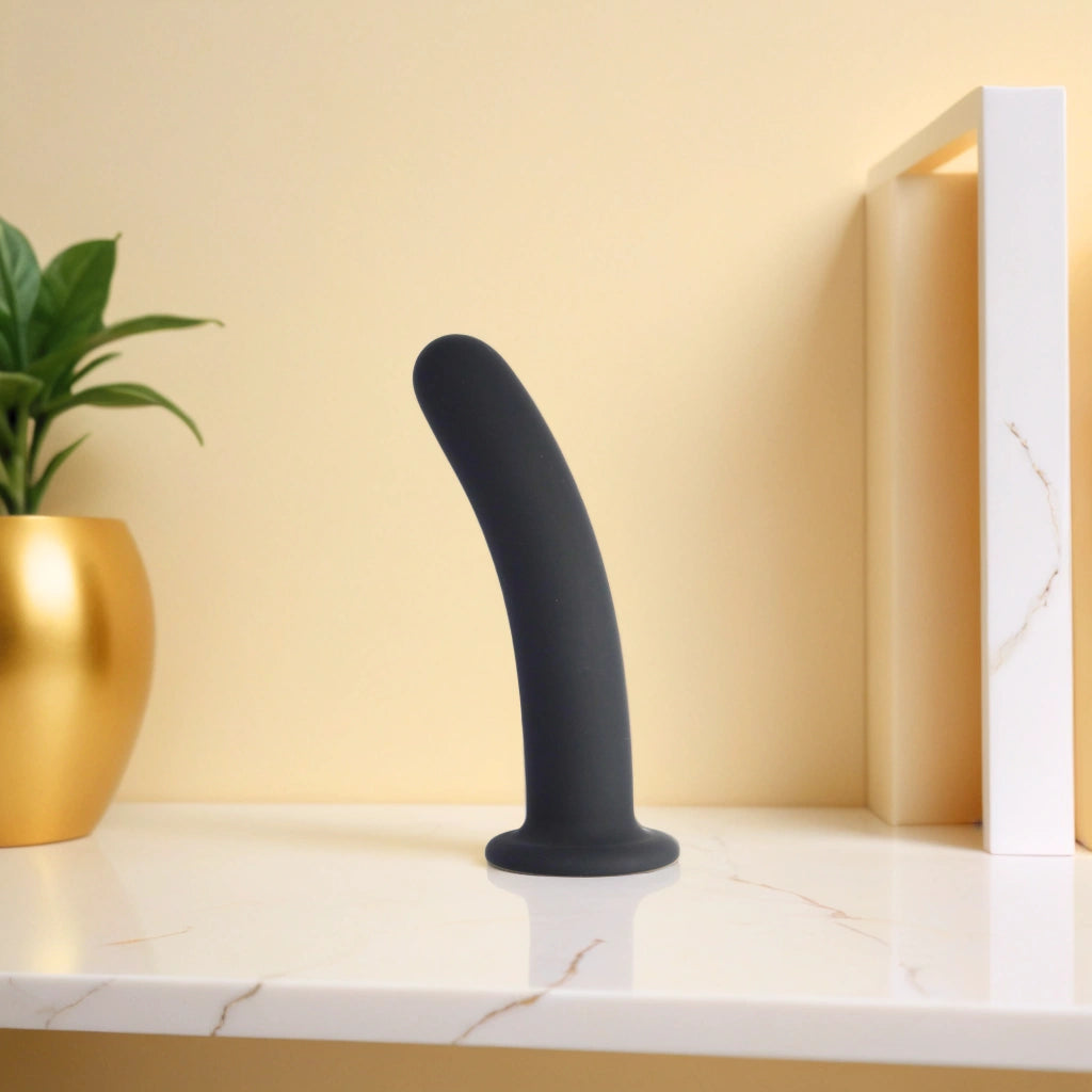 Dildo noir en silicone posé sur une surface élégante, conçu pour intensifier le plaisir avec des jeux de température chauds ou froids