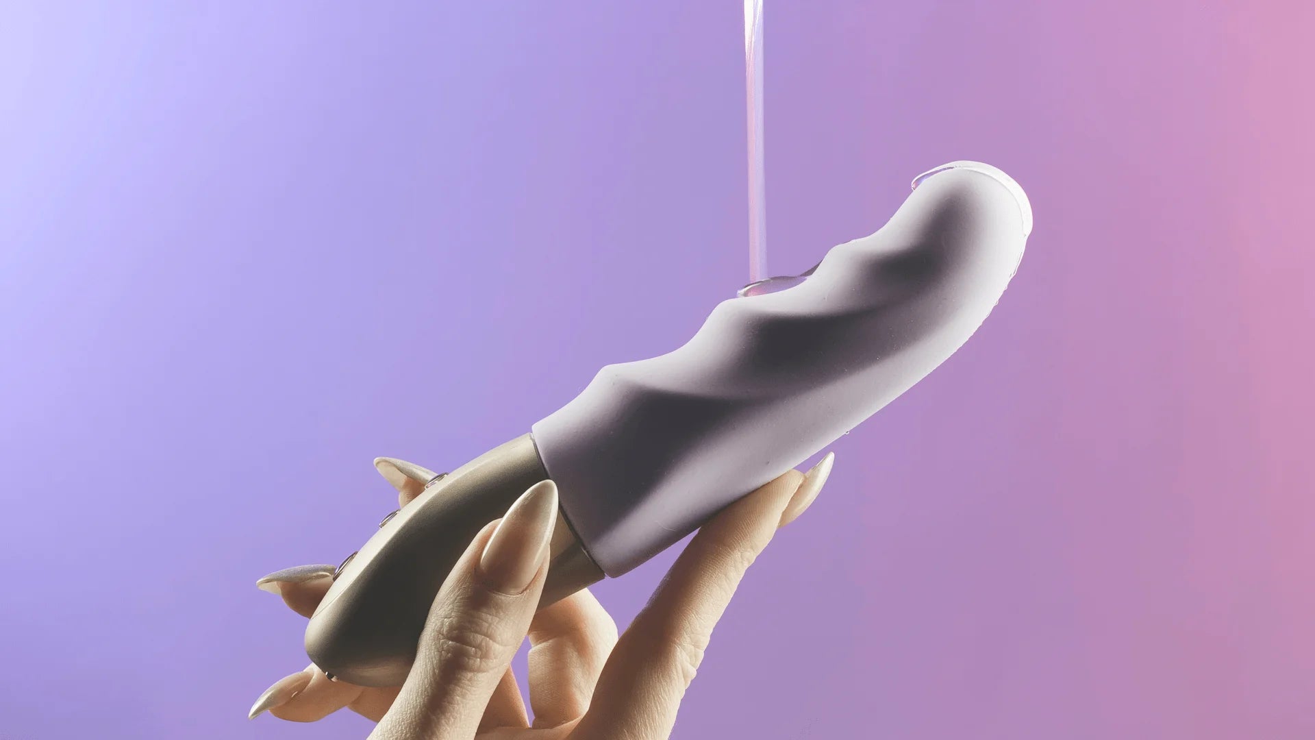 Lubrifiant versé sur un sextoy en silicone tenu par une main, illustrant la compatibilité idéale du lubrifiant Easyglide avec les jouets intimes, pour une expérience douce et sans friction