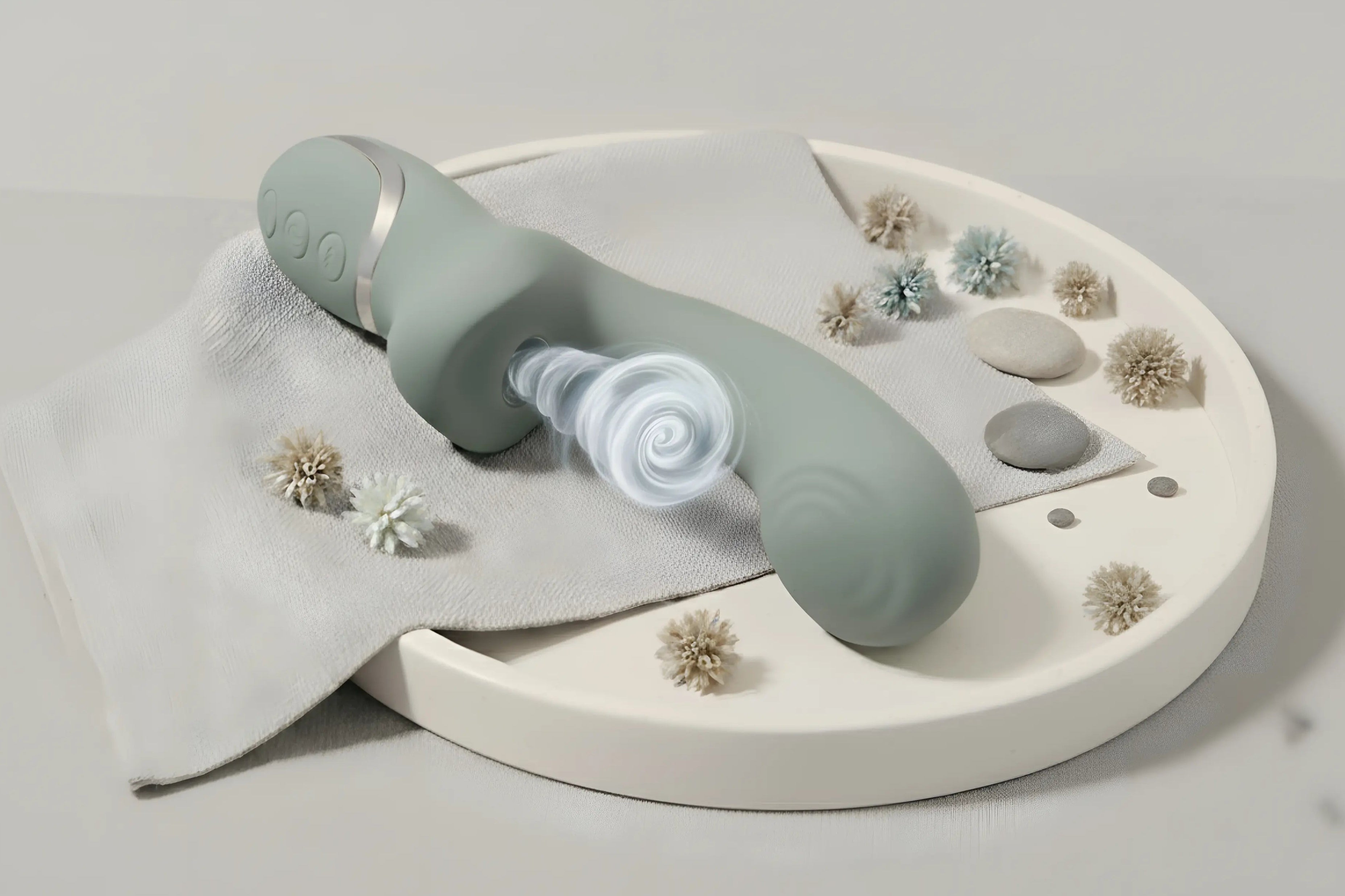 Vibromasseur rabbit Mila au design ergonomique posé sur une pierre, entouré de plantes, pour une double stimulation naturelle et élégante