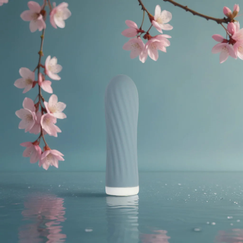 Vibromasseur bullet bleu Mira de Solena posé sur une surface d’eau calme, entouré de fleurs de cerisier, illustrant une prise en main douce et facile pour les débutantes